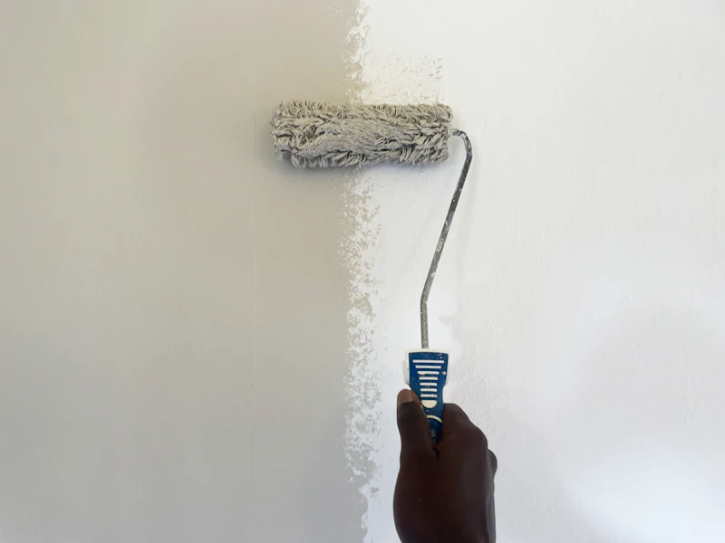 Rouleau chargé de peinture blanche sur un mur préparé